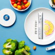 A plate of healthy food with a scale and measuring tape in the background