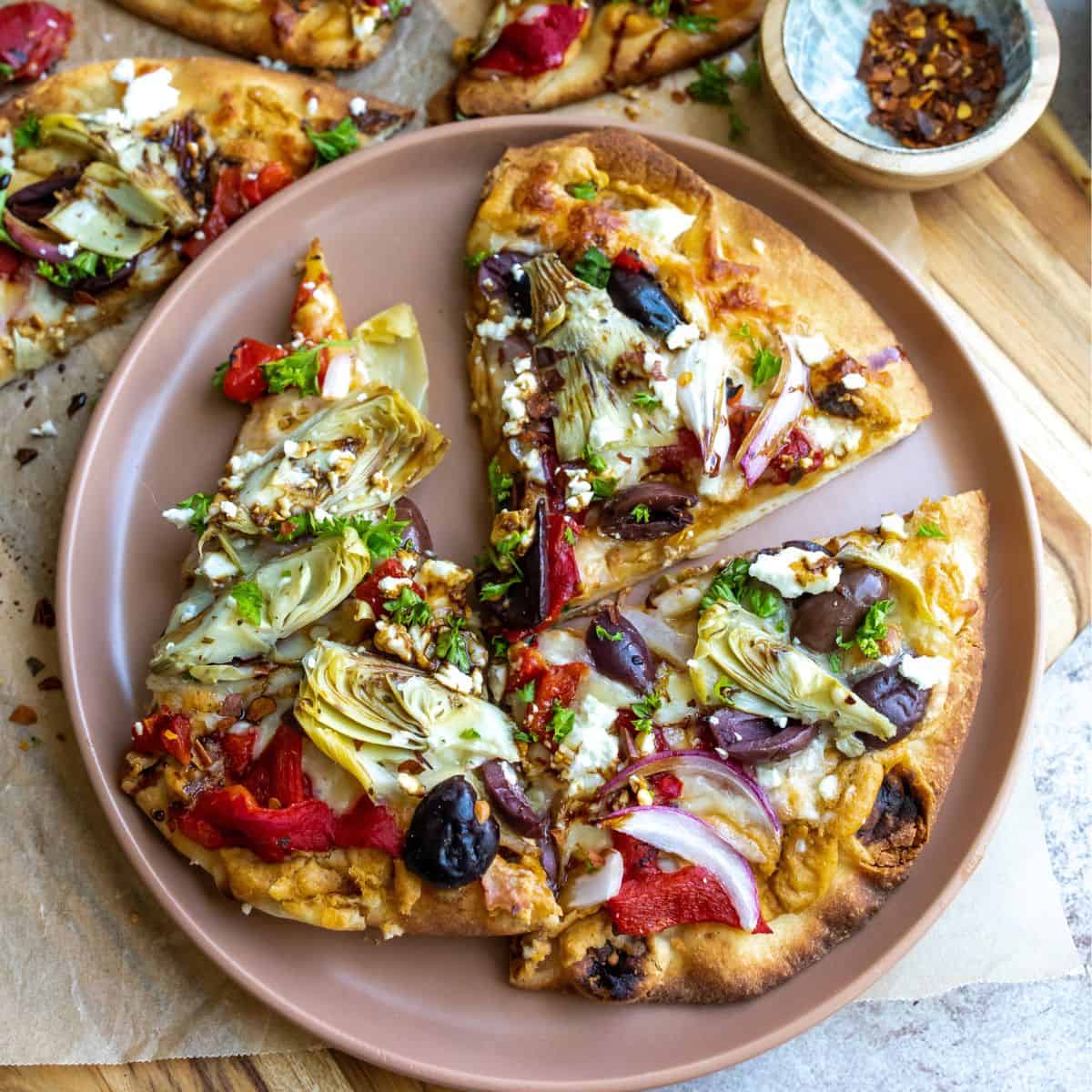 Mediterranean flatbread on a brown plate with parsley. 