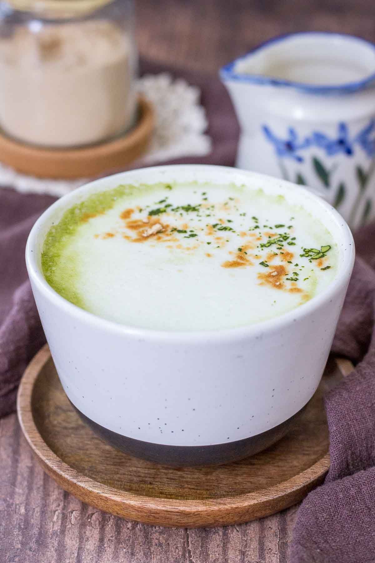 Matcha Maca Latte served in a mug topped with matcha green tea powder and maca powder