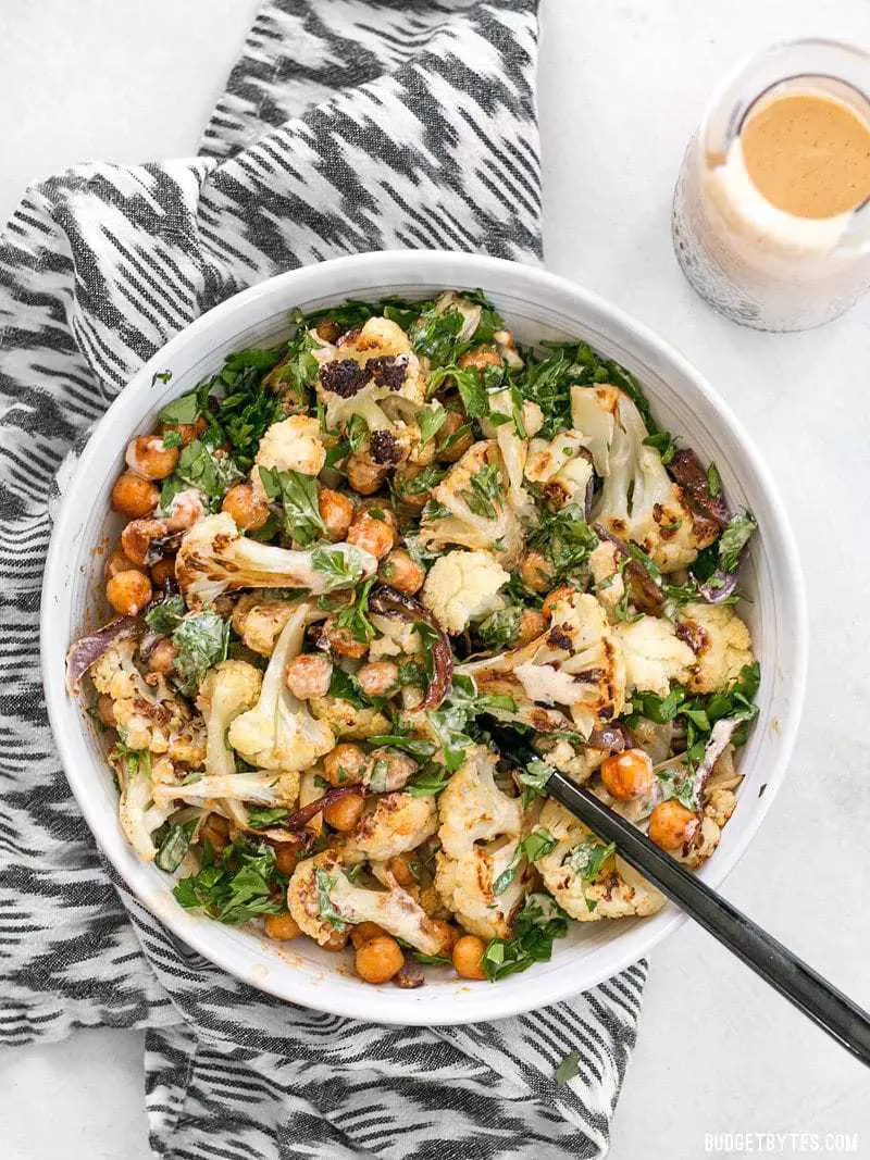 Overhead shot of a bowl full of Roasted Cauliflower Salad on a striped napkin